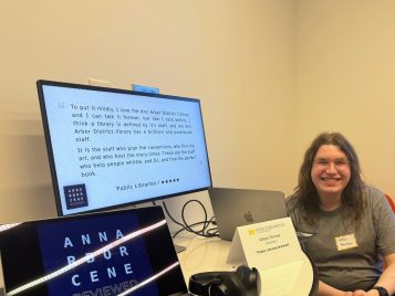 Willow Dimmer sitting by a laptop with their project, "Public Libraries/★★★★★."